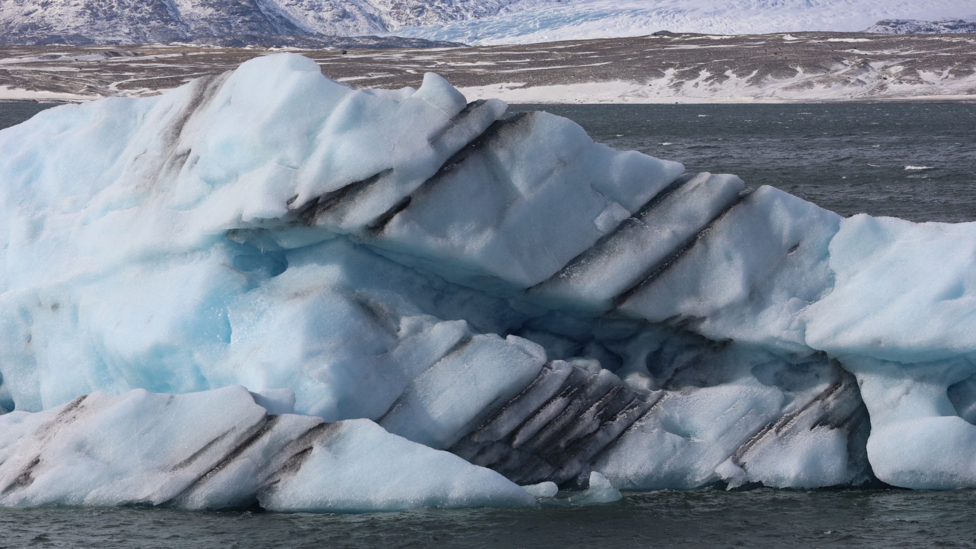 Iceberg con striature nere di cenere vulcanica nella laguna di Jökulsárlón Islanda
